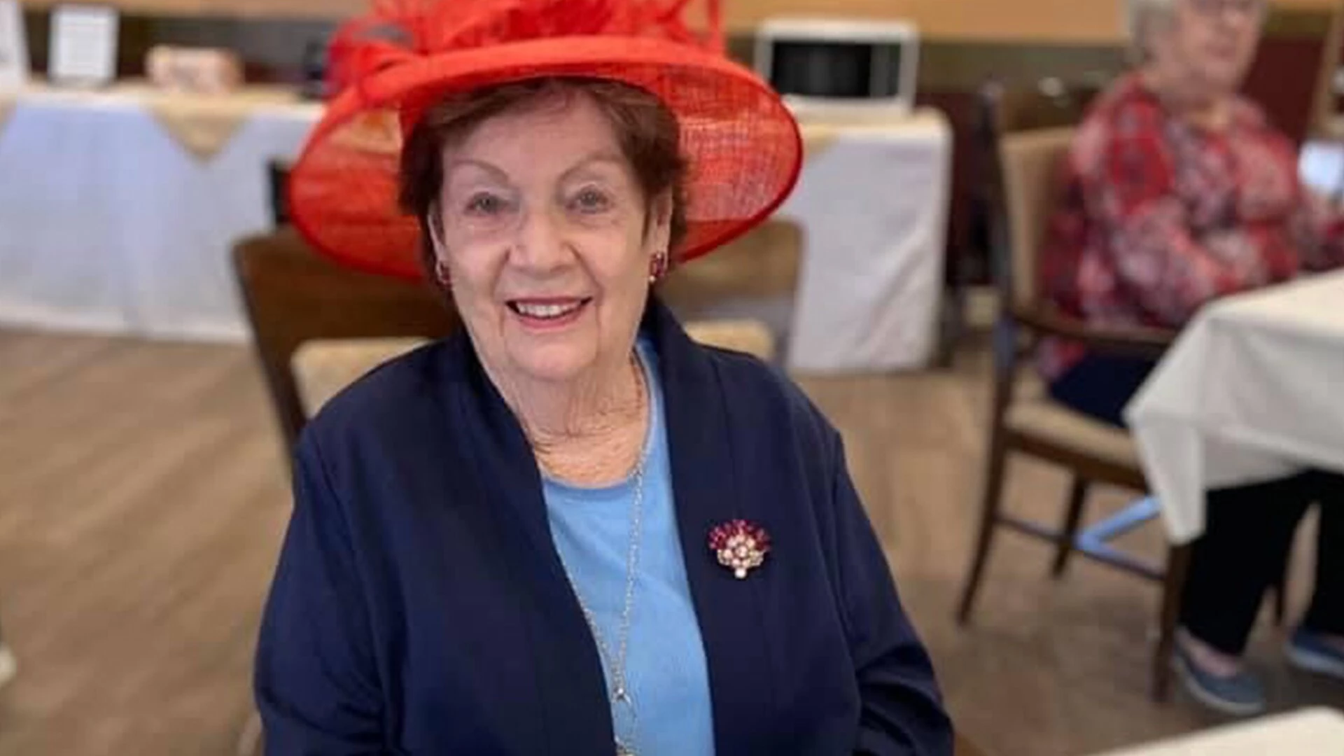 An elderly lady with a red hat