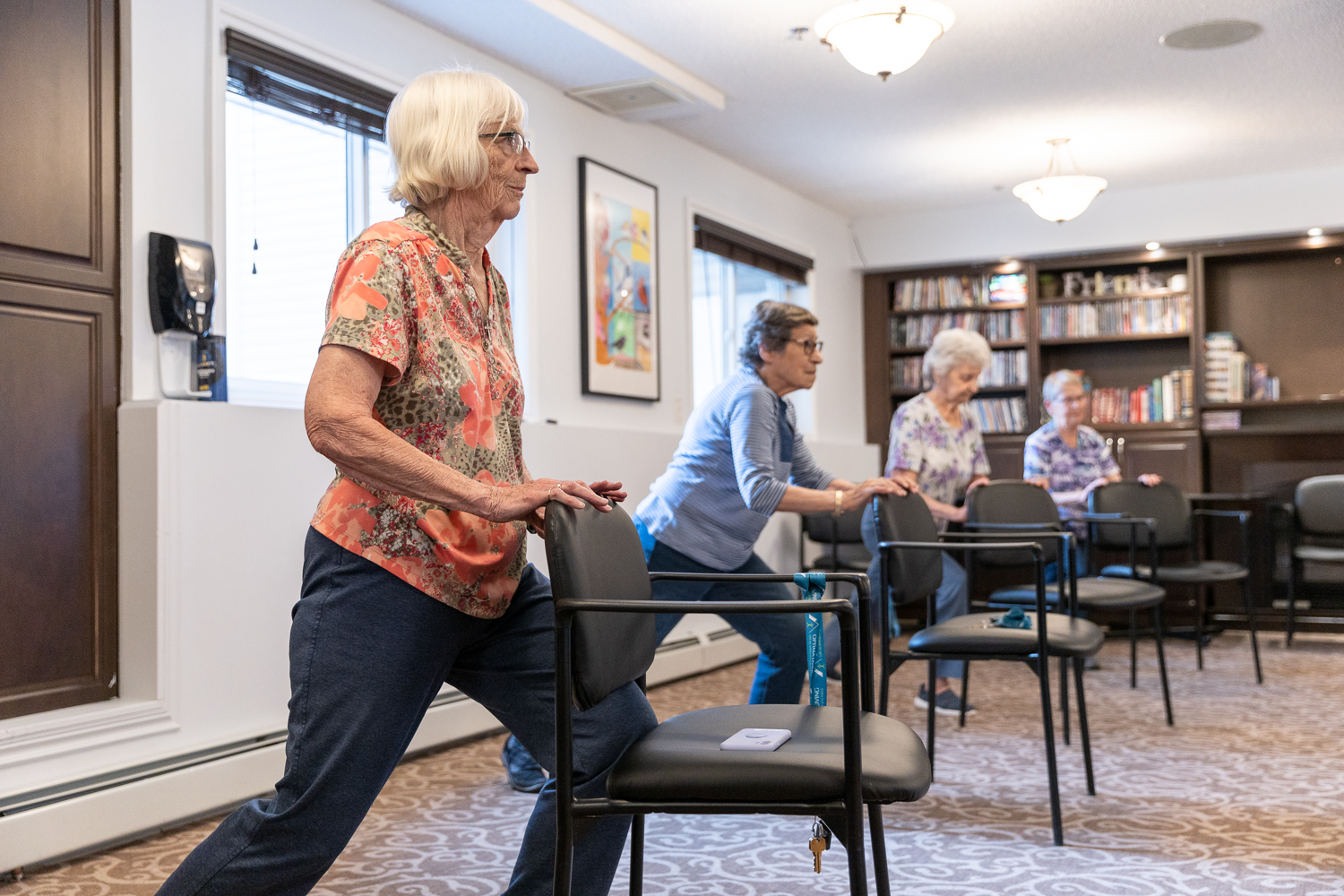 Residents stretching against chairs