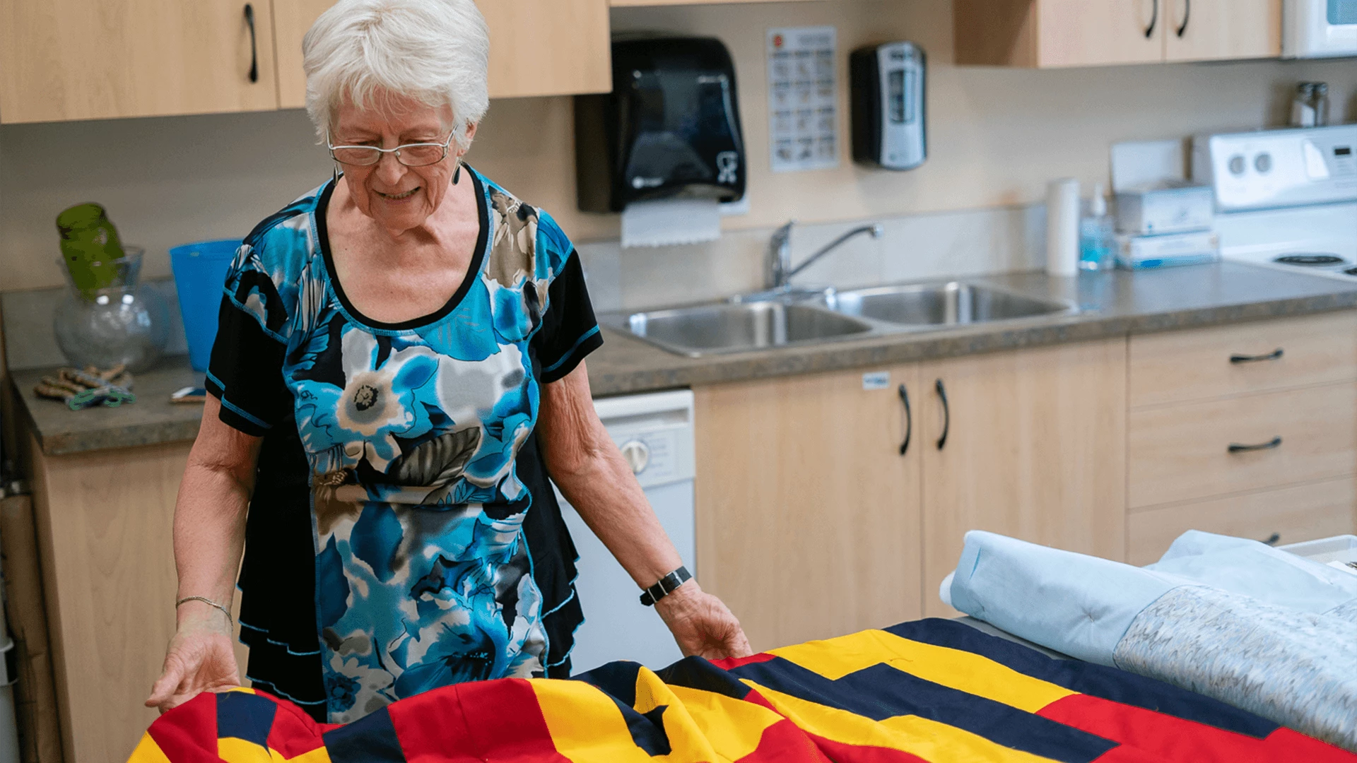 An elderly lady setting bedsheet in her room
