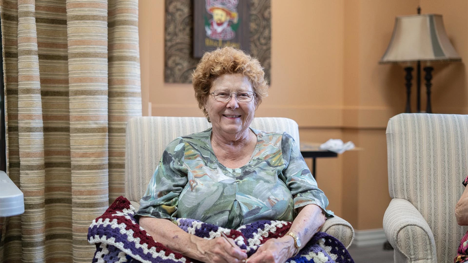 A senior woman smiling and holding a blanket