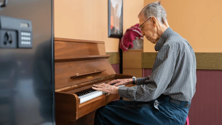At Cedarwood Station, an elderly man playing piano
